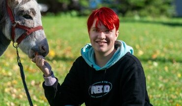 Tiergestützte-Therapie-Patientin-mit-Esel Eine junge Patientin mit Esel, die die tiergestütze Therapie der Universitätsmedizin nutzt.