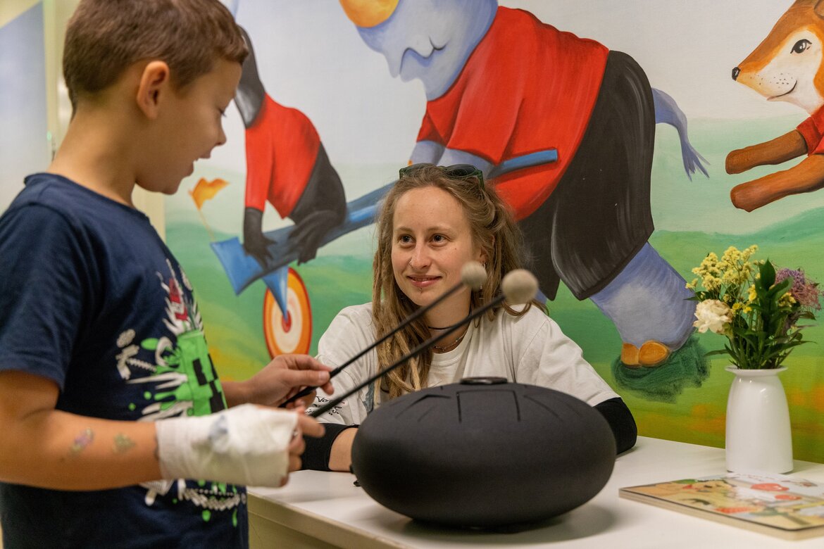 Auf dem Bild zu sehen ist die Musiktherapie auf der Kinderkardiologie der Universitätsmedizin Göttingen. Ein kleiner Patient wird gerade von der Musiktherapeutin an der Klangschale angeleitet,
