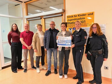 Auf dem Bild zu sehen ist die Spendenübergabe der Polizeuidirektion an das rein aus Spenden finanzierte Sportprojekt Luftsprung vor der Klinik für Kinder- und Jugendmedizin. Die Polizeipräsidentin der Polizeidirektion Göttingen übergibt den Spendencheck an das Team von Luftsprung.